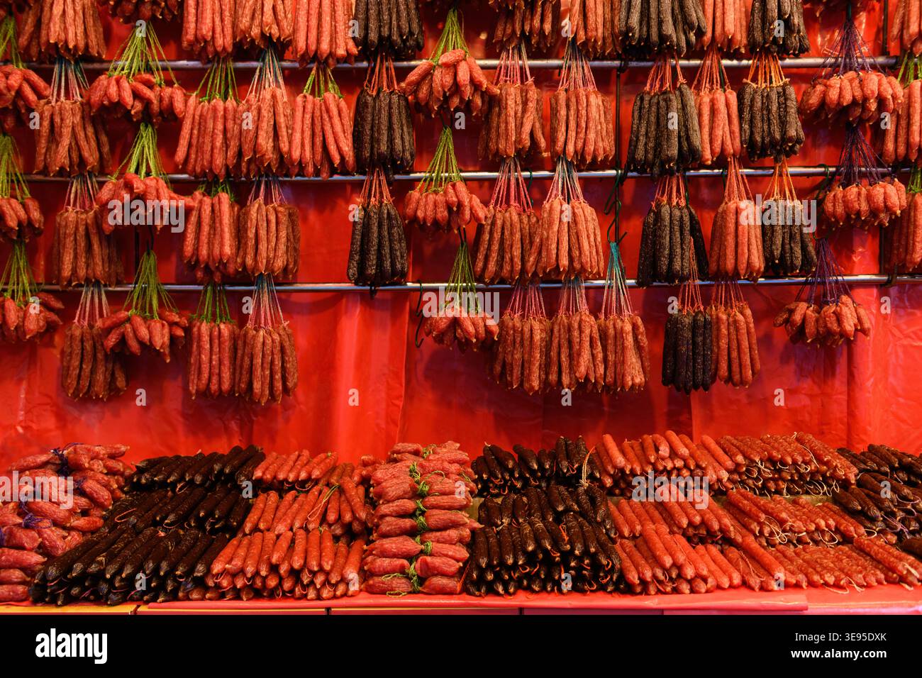 Stringhe di salsicce cinesi di lap cheong, una salsiccia di maiale salata e dolce, un punto fermo della cucina cantonese, appesa in una bancarella di mercato a Singapore. Foto Stock