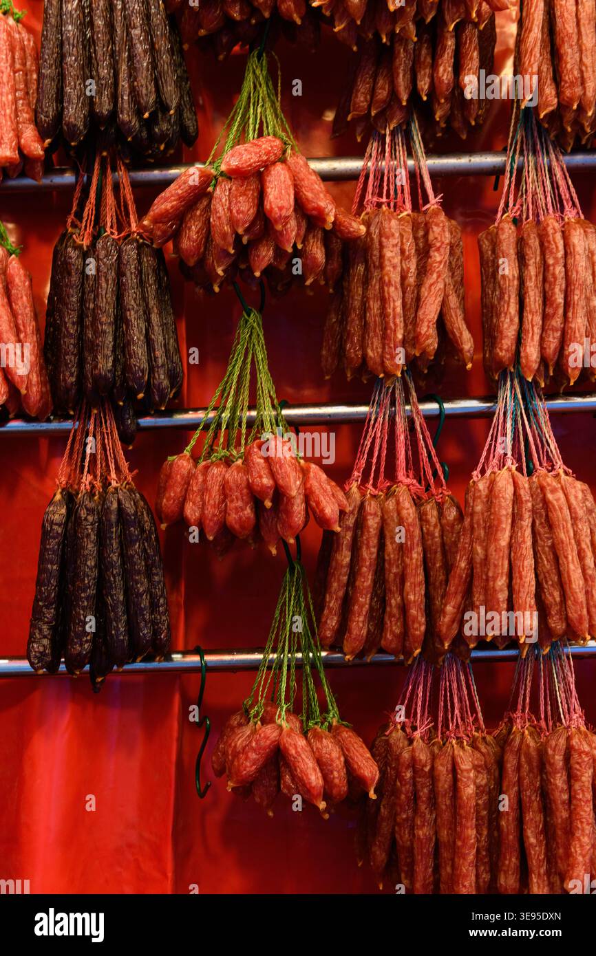 Stringhe di salsicce cinesi di lap cheong, una salsiccia di maiale salata e dolce, un punto fermo della cucina cantonese, appesa in una bancarella di mercato a Singapore. Foto Stock