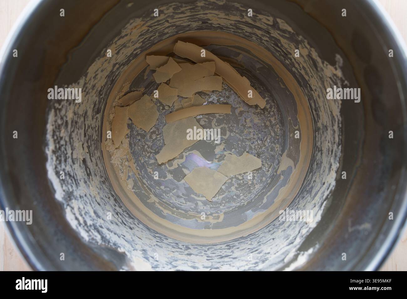 Interno di un distillatore d'acqua usato che mostra scaglie di calcare e depositi minerali sul tamburo metallico, indicando la contaminazione dell'acqua dura e dell'acqua di rubinetto Foto Stock