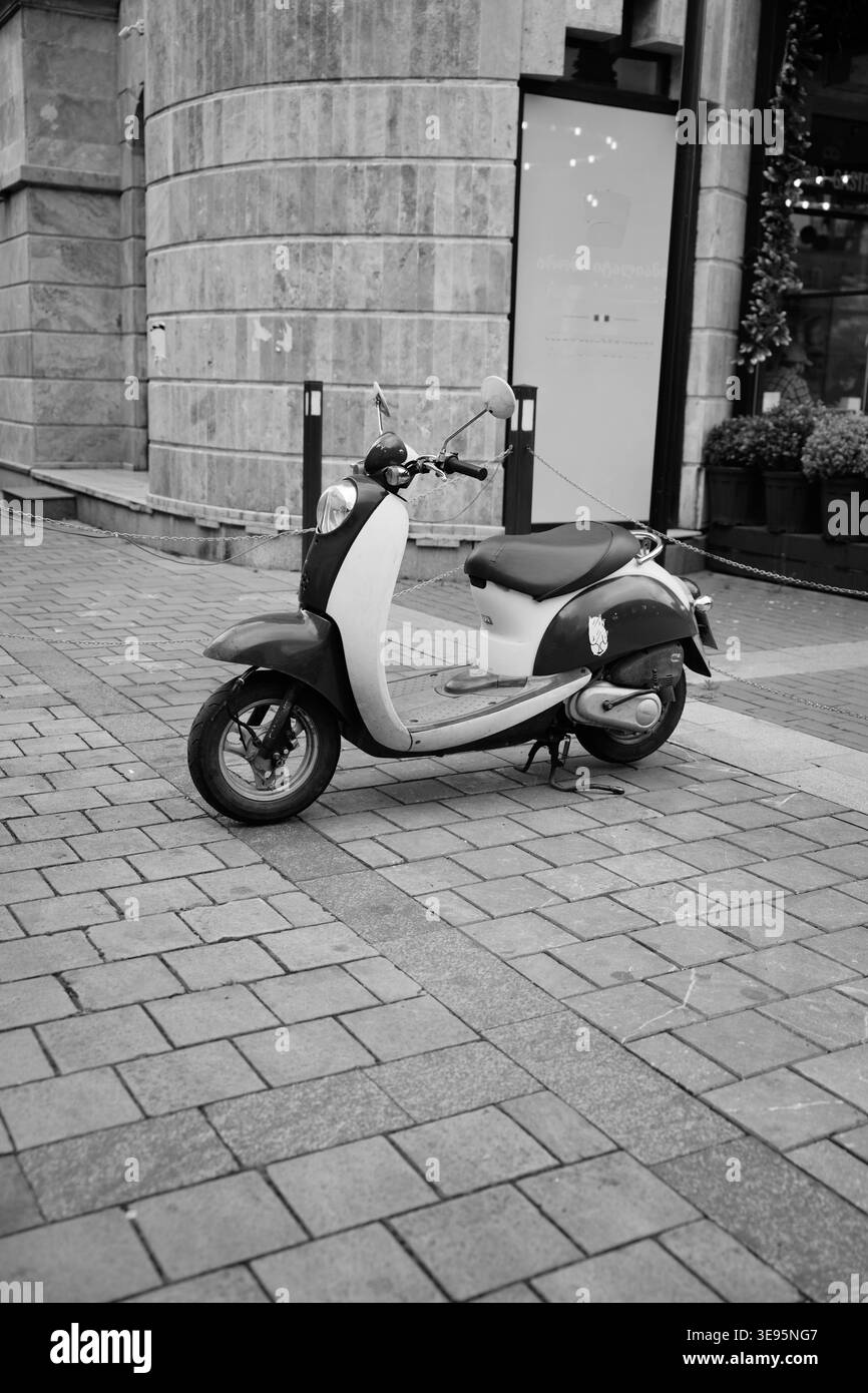 Fotografia in bianco e nero della motocicletta con sfondo urbano Foto Stock