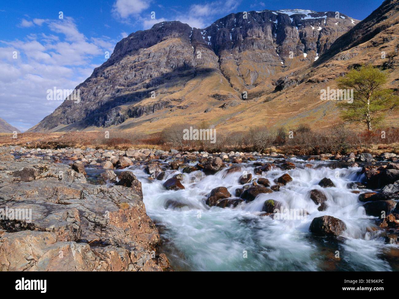 Il fiume Coe, con la montagna Aonach Dubh (Black Ridge), la vetta più occidentale della formazione delle "tre Sorelle" a Glencoe sullo sfondo, in Scozia Foto Stock