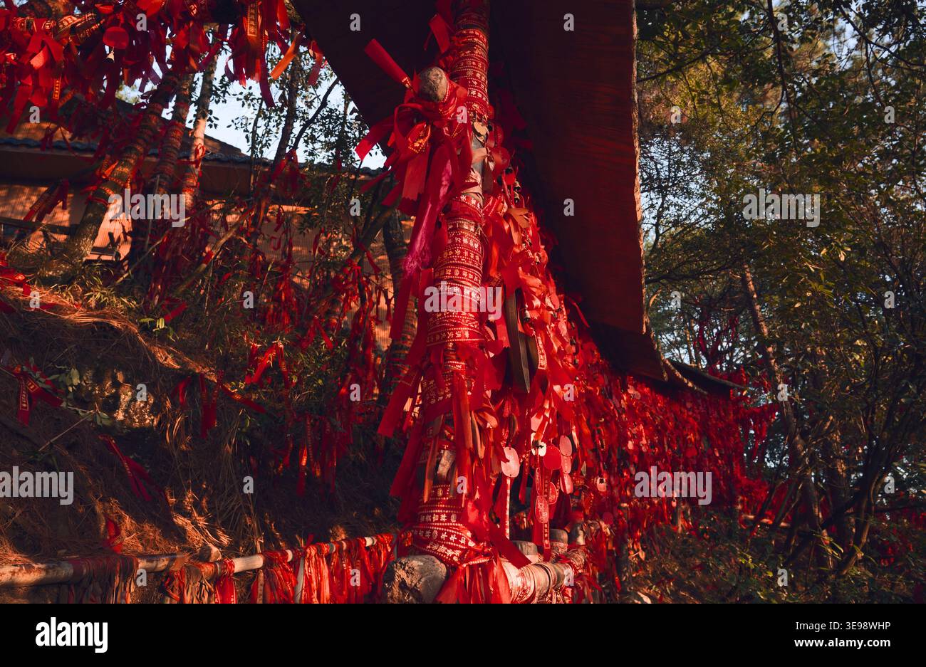 Ringhiera in legno coperta da nastri rossi e chiuse lungo il sentiero della foresta nel Parco nazionale della foresta di Zhangjiajie Foto Stock