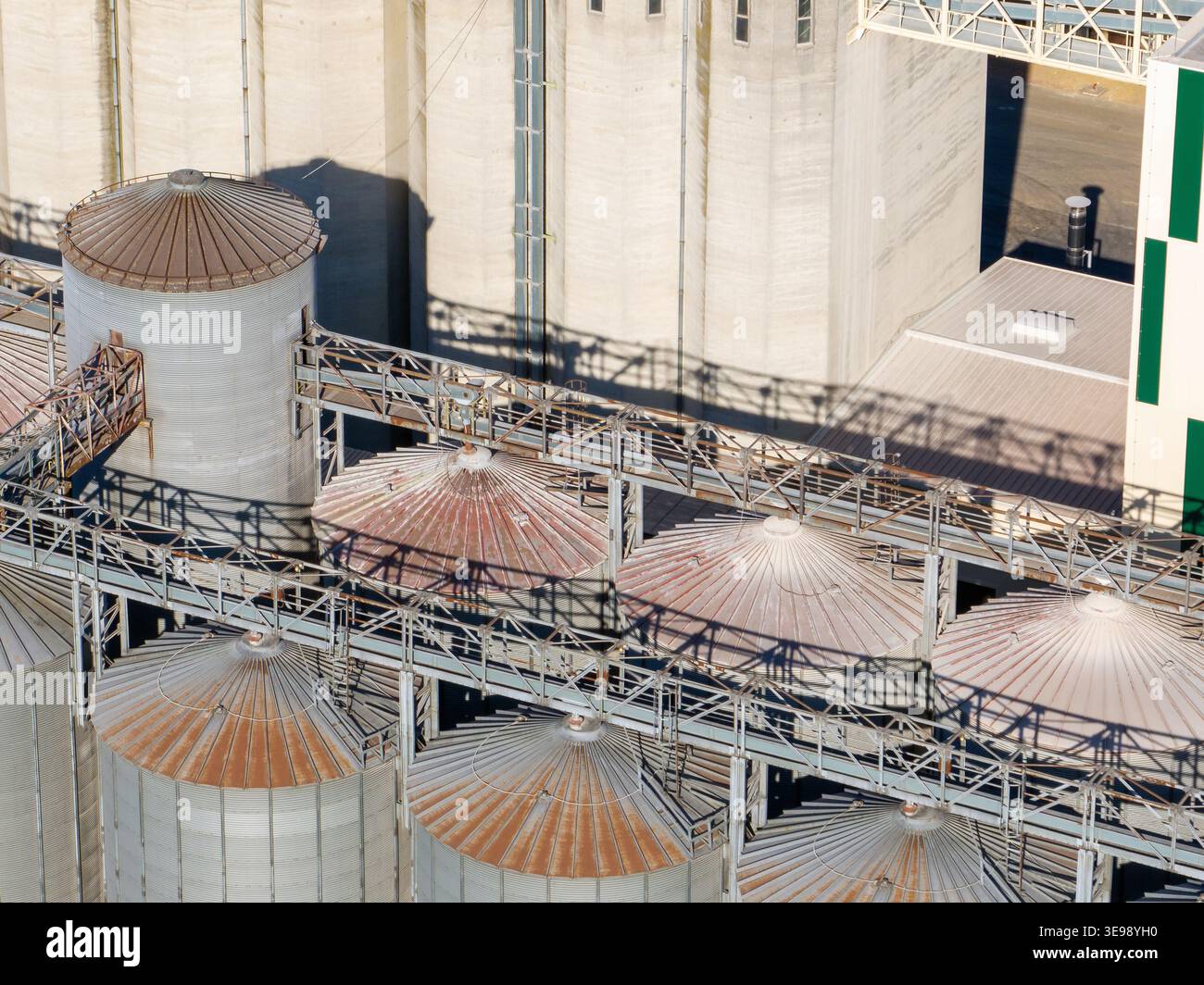 La vista mostra i silos di grano e le strutture di stoccaggio in un ambiente rurale. L'infrastruttura supporta la lavorazione e la distribuzione delle colture. Foto Stock