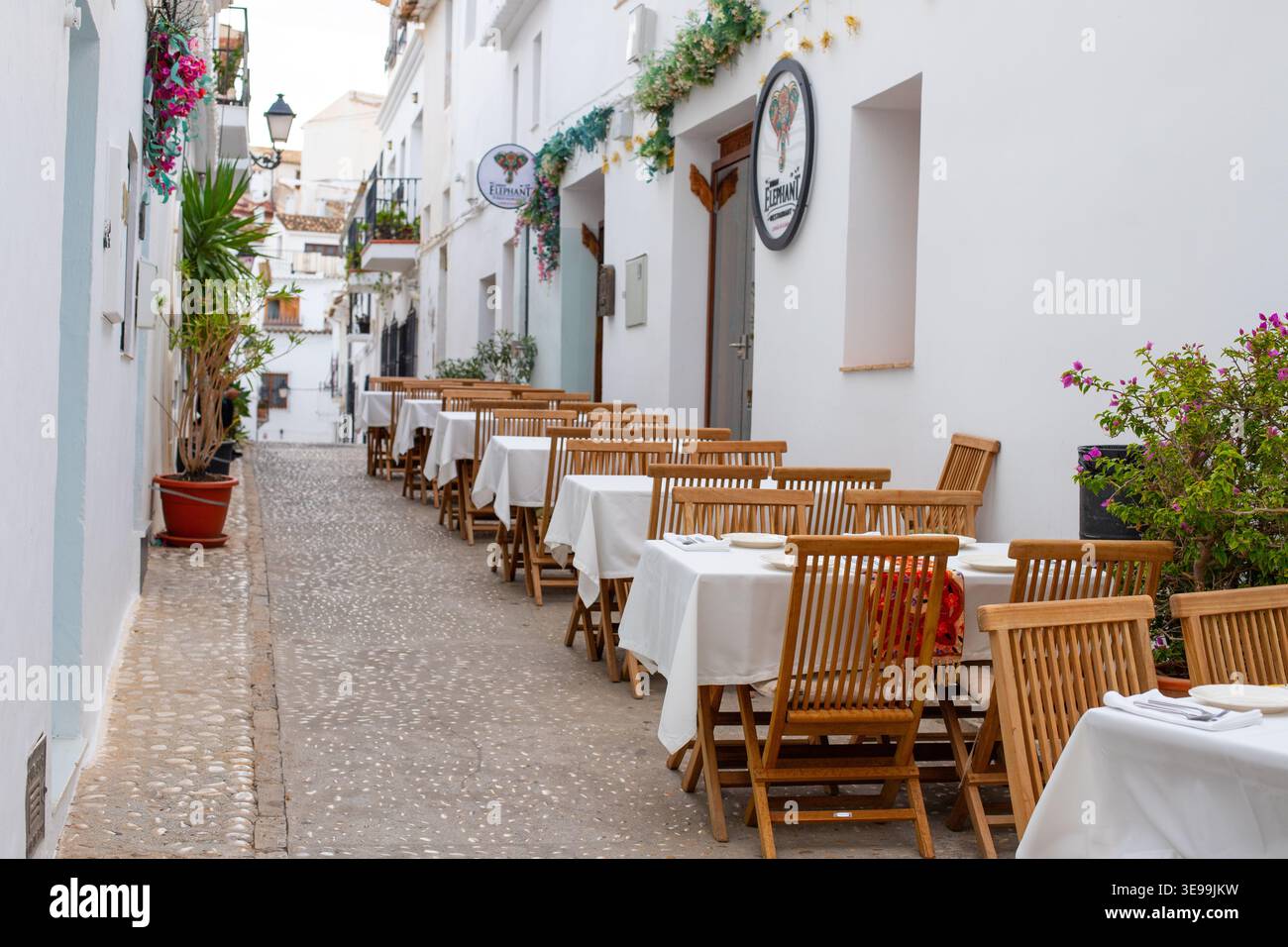 L'affascinante panorama di Altea Street invita i viaggiatori a cenare all'aperto in un caffè in Spagna, perfetto per vacanze in famiglia e vacanze rilassanti Foto Stock