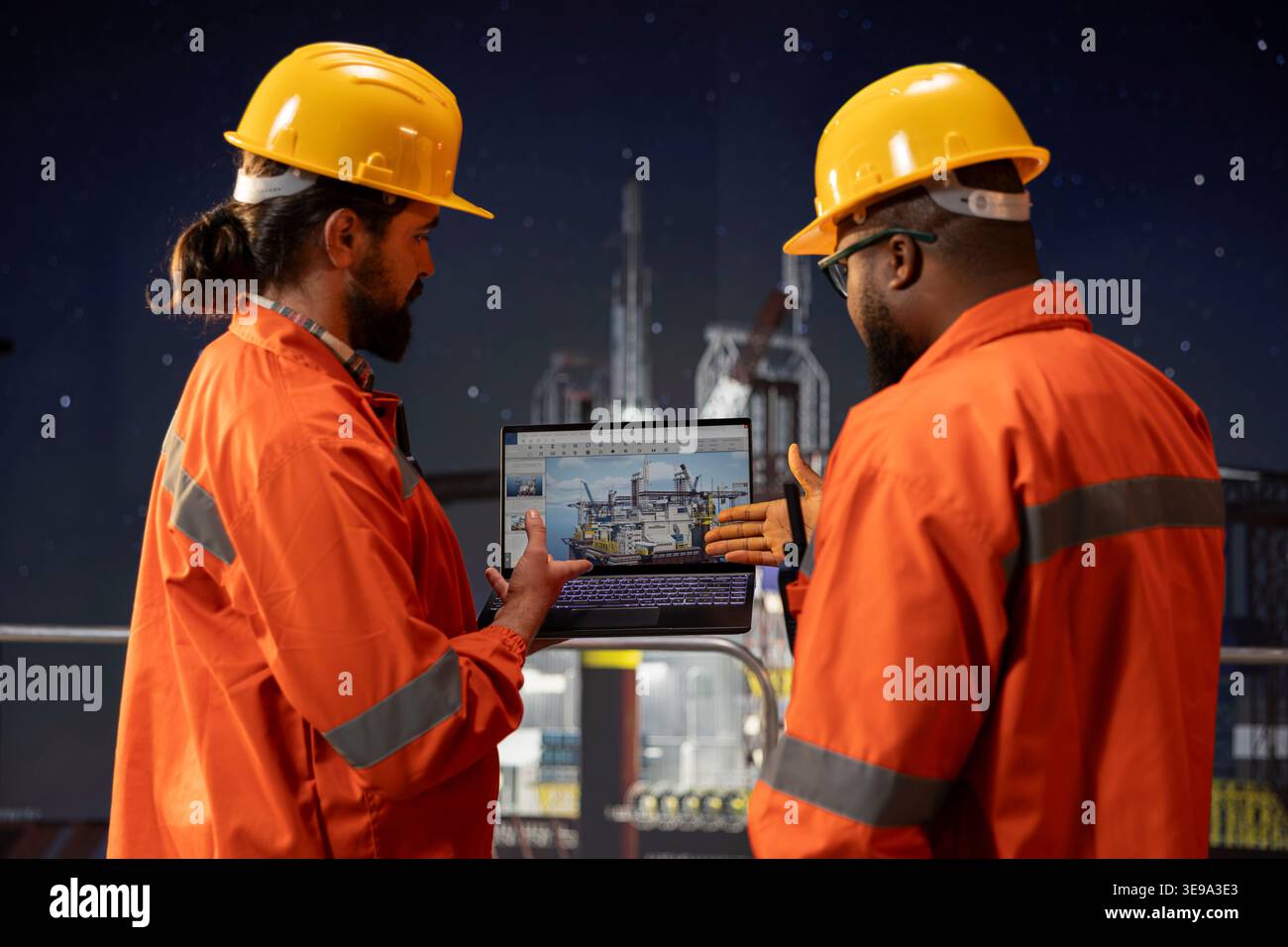 I lavoratori della piattaforma marittima offshore monitorano le operazioni utilizzando un software per laptop di notte. I colleghi del carro di perforazione osservano i dati dei sensori per leggere le metriche di produzione sul notebook Foto Stock