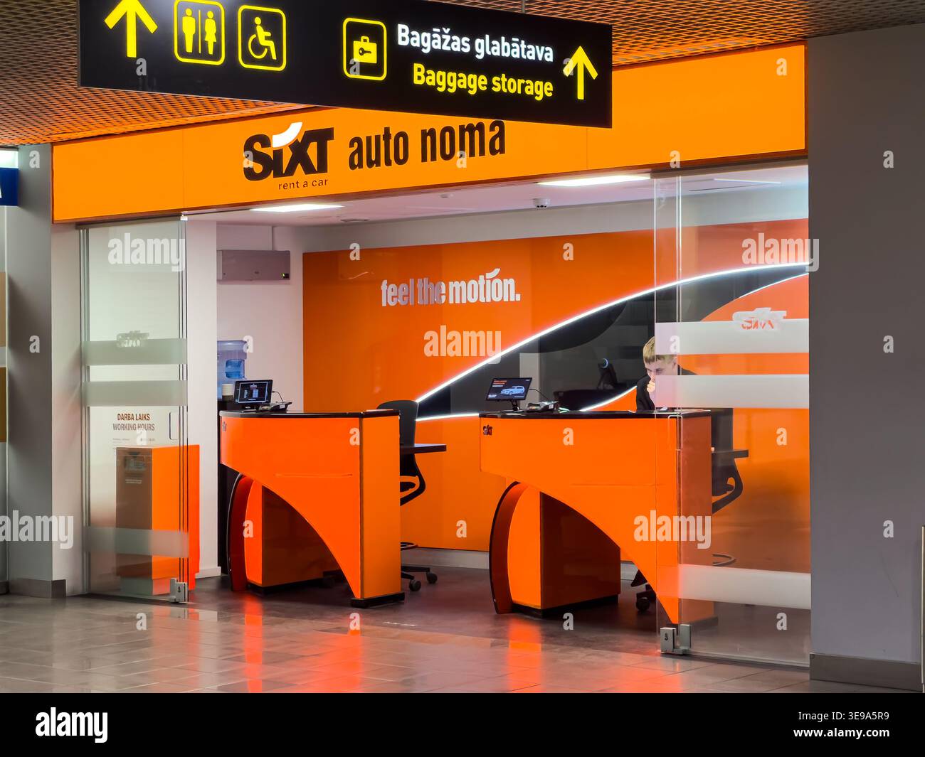 Riga, Lettonia - 3 aprile 2026: Banco di noleggio auto Sixt in un aeroporto con marchio arancione e cartellonistica, che mostra un design moderno e un servizio clienti Foto Stock