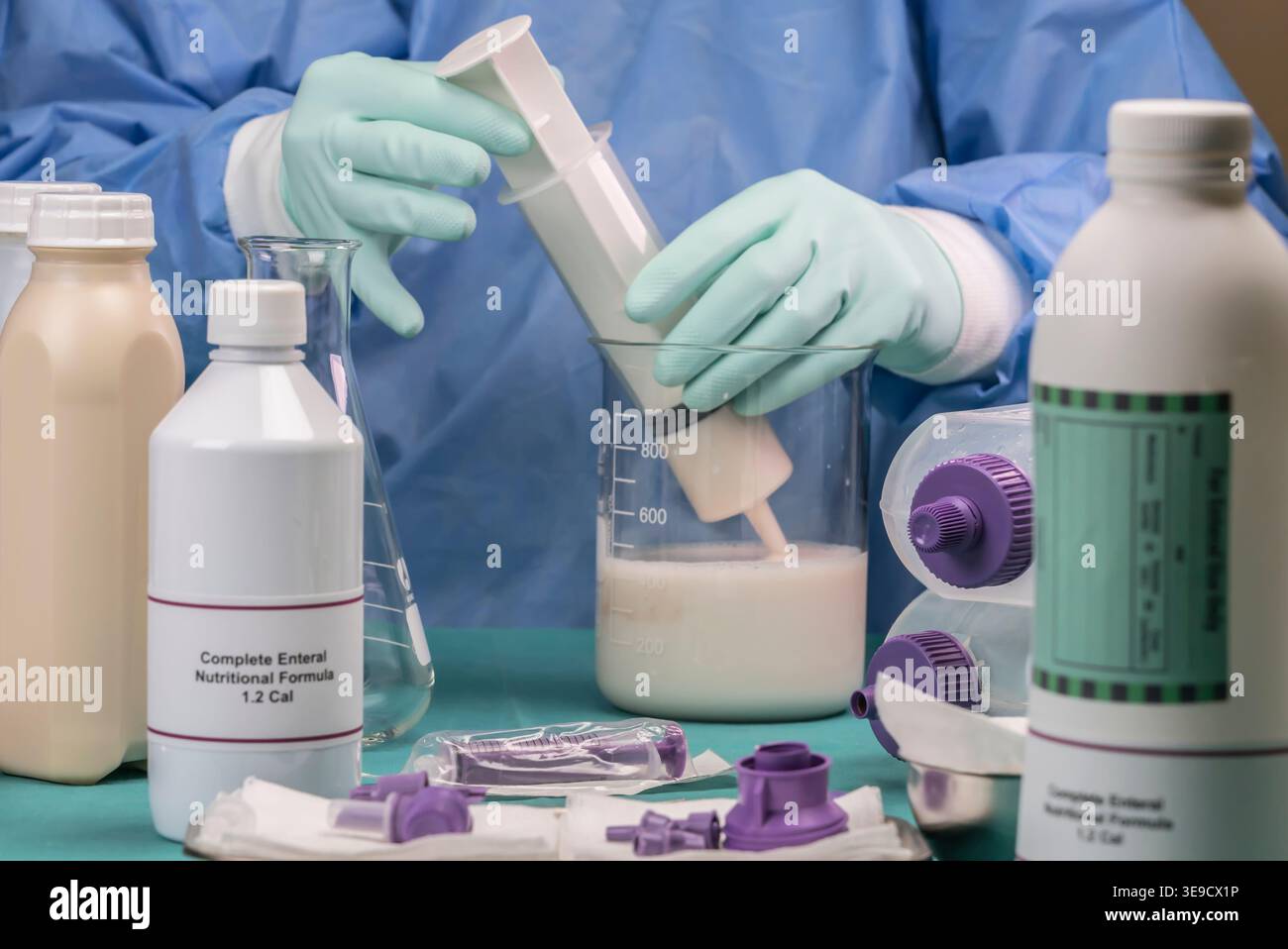 L'infermiere estrae il contenuto nutrizionale enterale con siringa, cura paillativa in ospedale, immagine concettuale Foto Stock