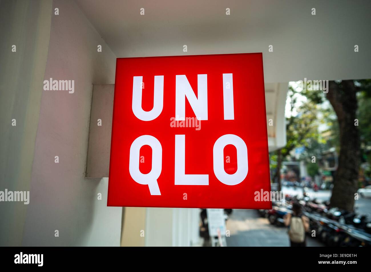 Ingresso al famoso negozio di abbigliamento giapponese con un cartello rosso Western Uniqlo che mostra il logo sulla parete. Foto Stock