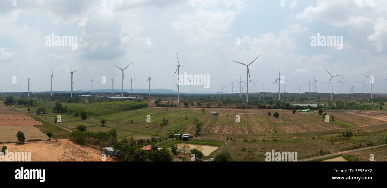 Una vista panoramica di una centrale eolica integrata in un paesaggio agricolo rurale che illustra la produzione di energia sostenibile. Foto Stock