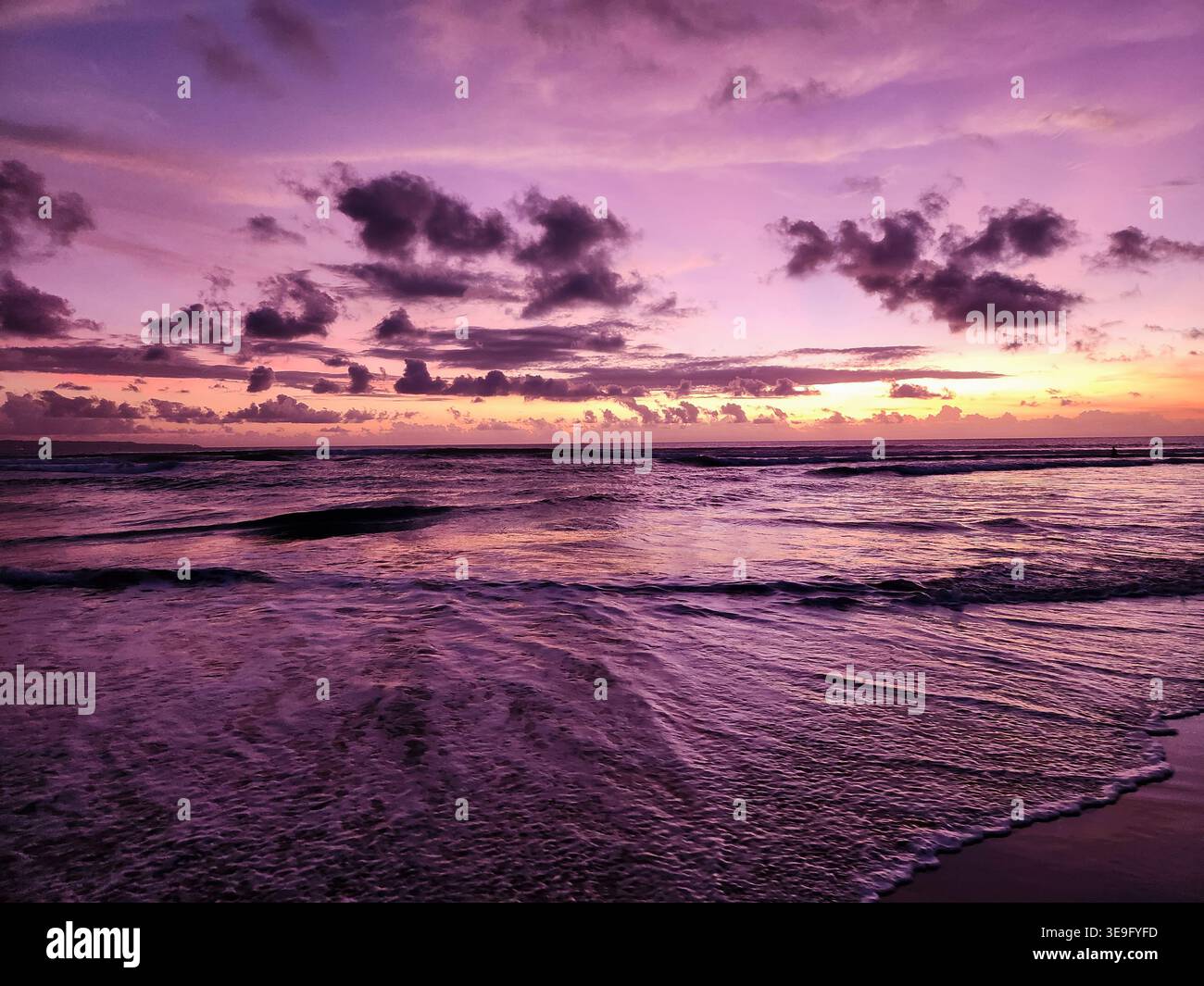 Tramonto viola sulla spiaggia a Bali, Indonesia Foto Stock