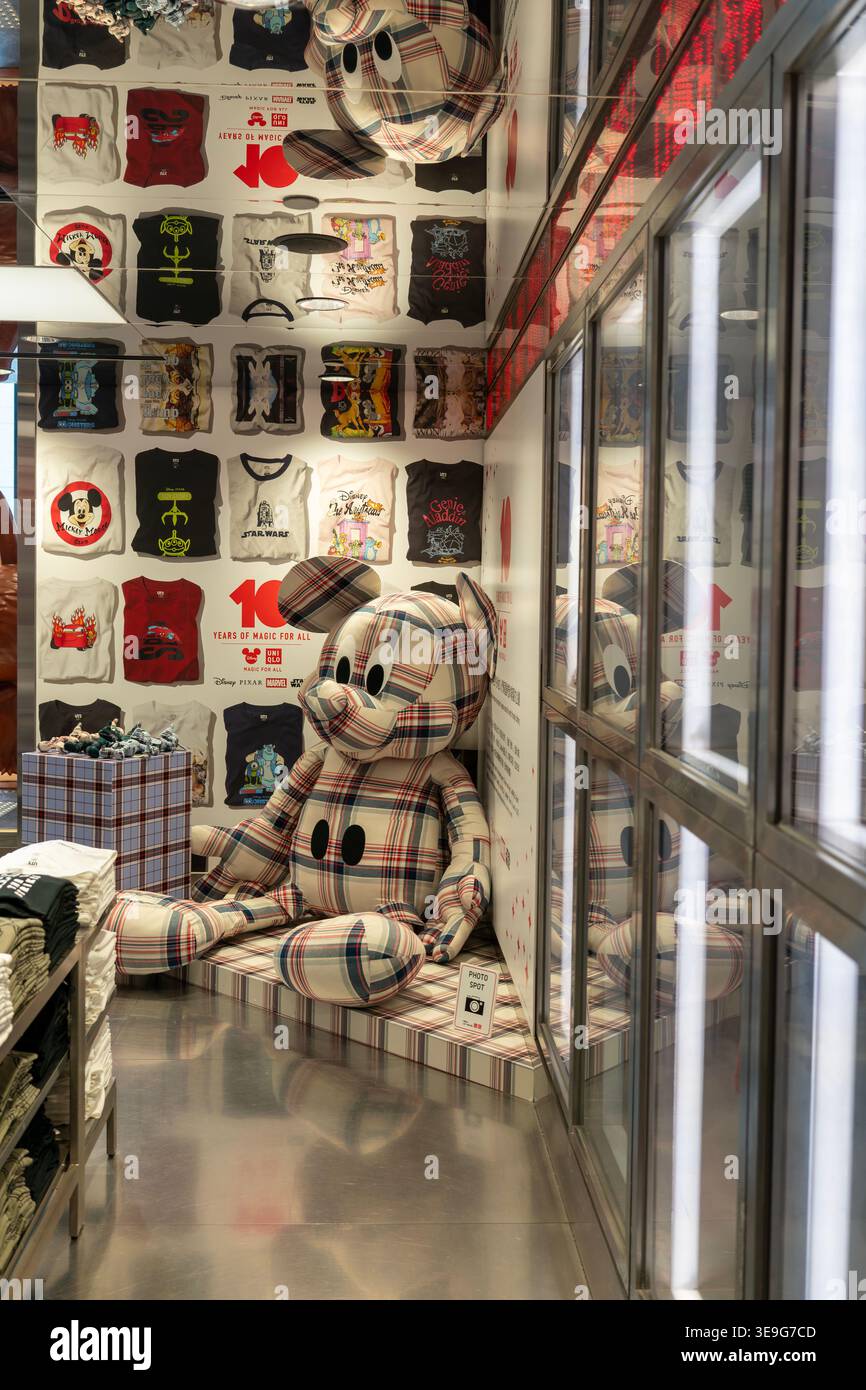 Hong Kong, Cina - 23 settembre 2025: Statua a quadri di Topolino e magliette grafiche della collezione Disney all'Uniqlo Lee Theatre. Foto Stock
