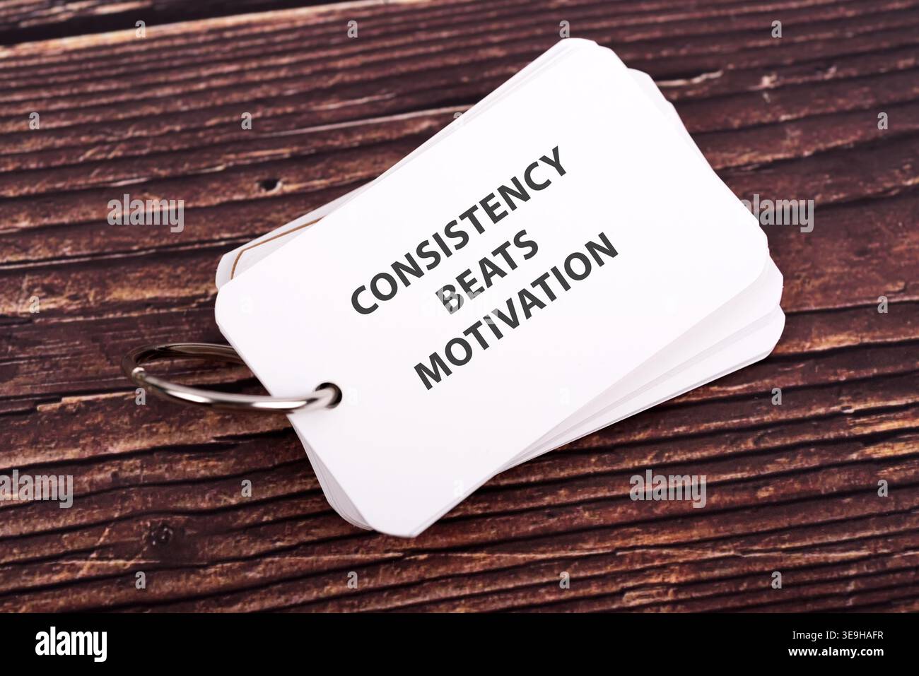 Memo pad con citazioni ispiratrici la coerenza batte la motivazione Foto Stock