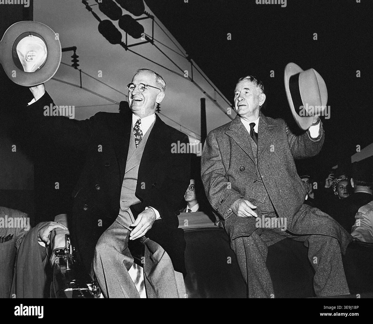 Il presidente degli Stati Uniti Harry S. Truman (a sinistra) e il vicepresidente eletto degli Stati Uniti Alben W. Barkley (a destra) seduti sul retro di un veicolo aperto alla stazione ferroviaria al loro ritorno, salutando i loro cappelli alla folla dopo aver vinto le elezioni del 1948, Washington, D.C., USA, Abbie Rowe, National Parks Service, Harry S. Truman Library, 5 novembre 1948 Foto Stock