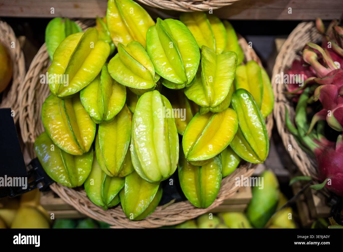 Carambola di frutta esotica matura a forma di stella nel cesto in mostra in vendita in Thailandia. Foto Stock