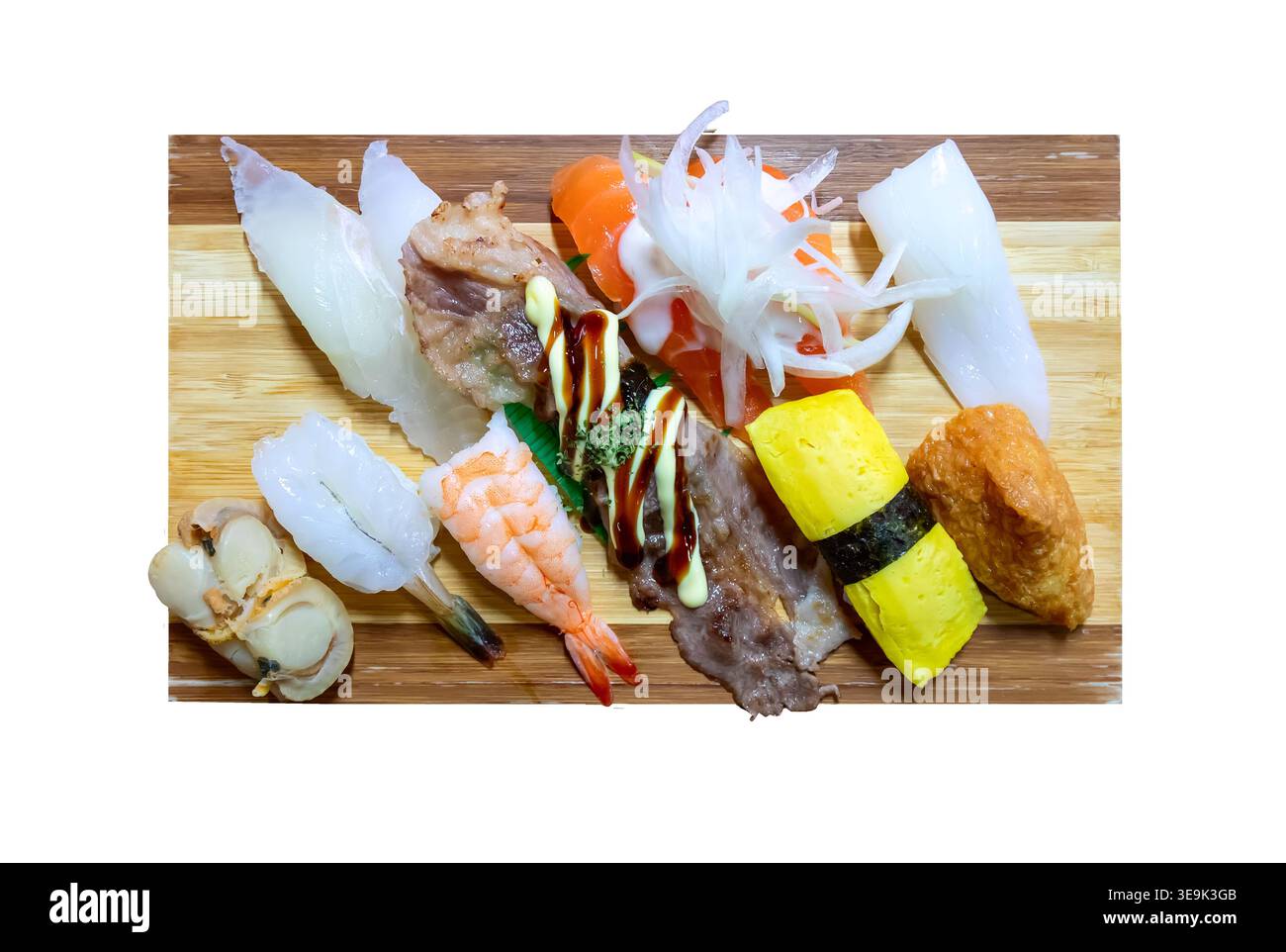 Piatto di sushi nigiri assortito servito su una tavola di bambù di legno isolata su sfondo bianco, con gamberi, calamari, pesce, tamago all'uovo e inari Foto Stock