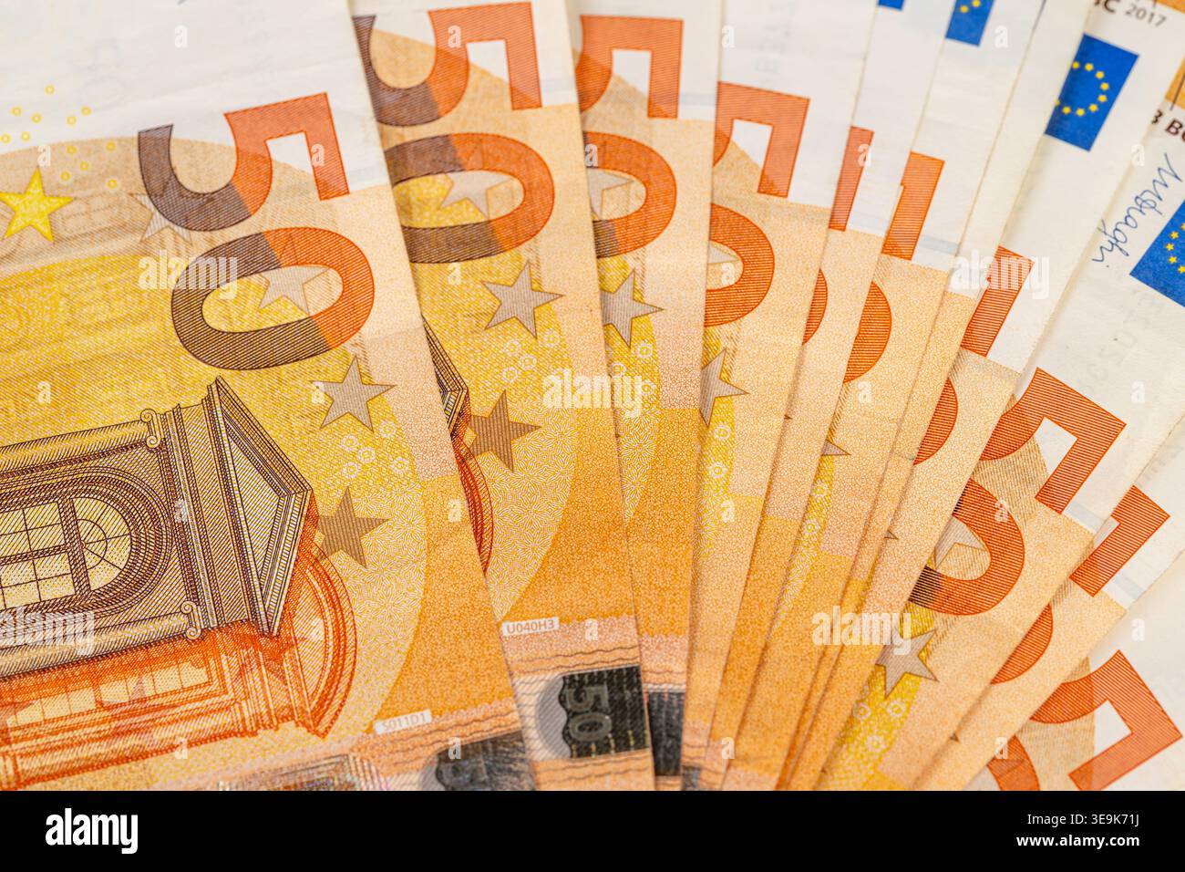 Le banconote in euro sgranate disposte per il pagamento, i vivaci dettagli seriali e i bordi stratificati formano una composizione dinamica che suggerisce il commercio, fino al conteggio, o SM Foto Stock