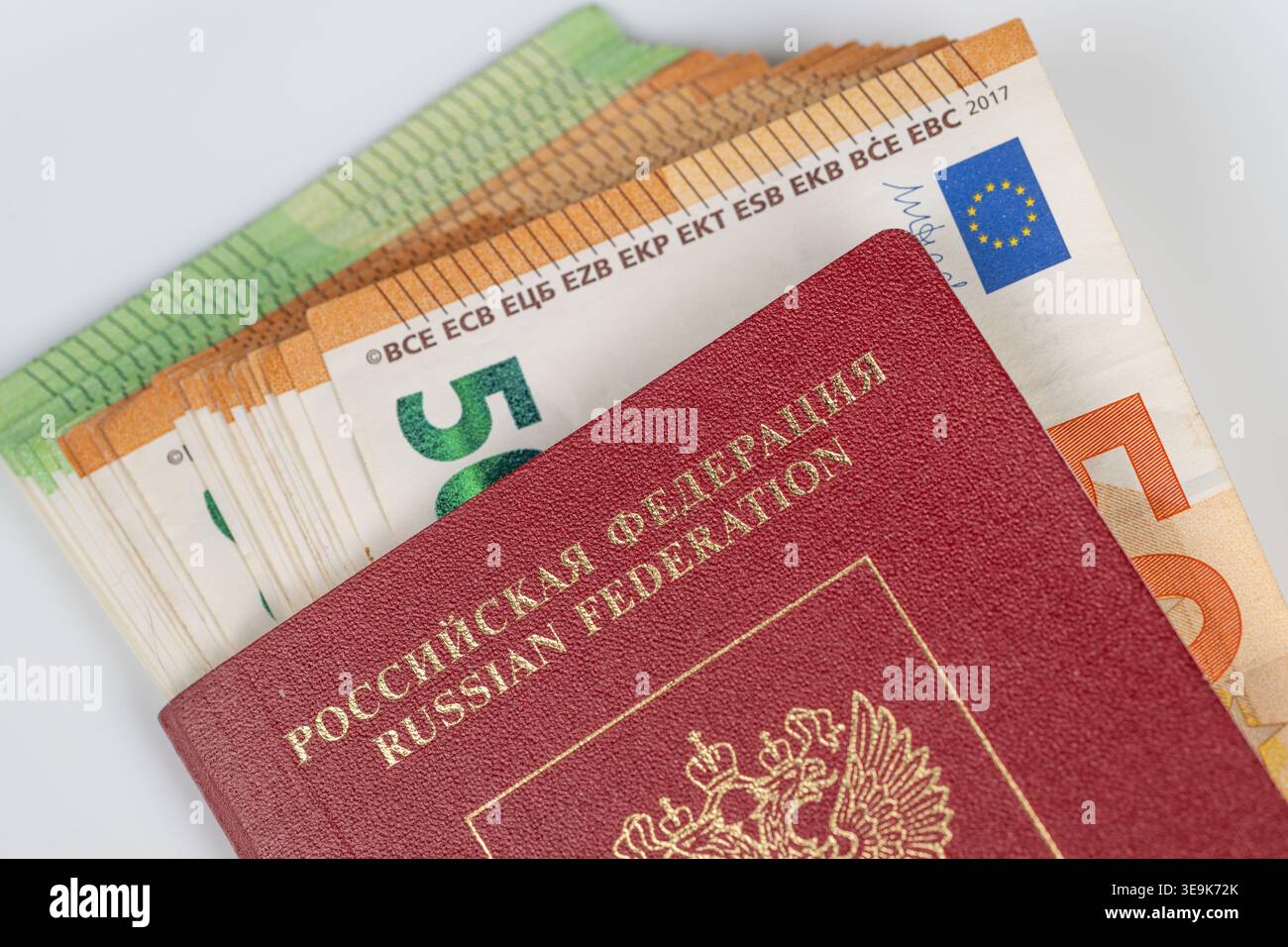 Bella pila di euro sotto il passaporto russo, scena finanziaria internazionale degli studenti, istruzione scolastica e pianificazione dei costi di vita, flatlay minimo, ombre silenziose Foto Stock