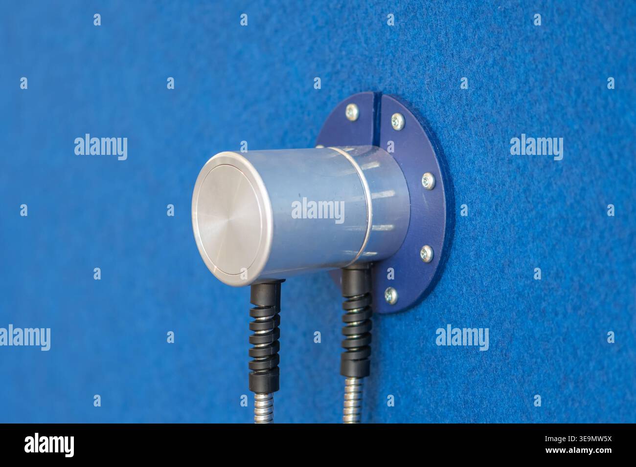 Dispositivo sensore in metallo montato su parete blu utilizzato per il controllo e la trasmissione del segnale. Foto Stock