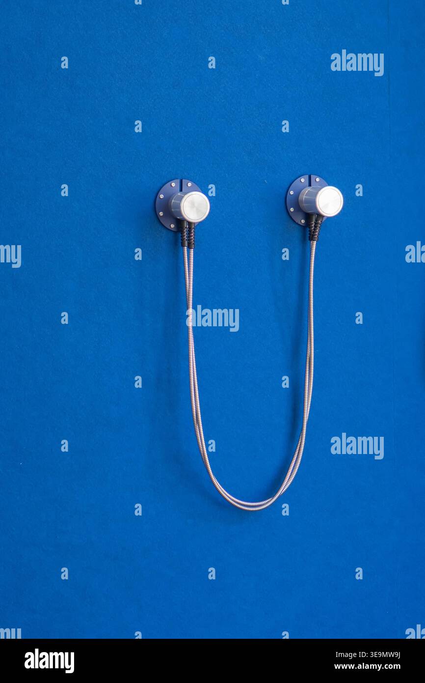 Due sensori collegati tramite cavo sulla parete blu utilizzati per la trasmissione del segnale. Foto Stock