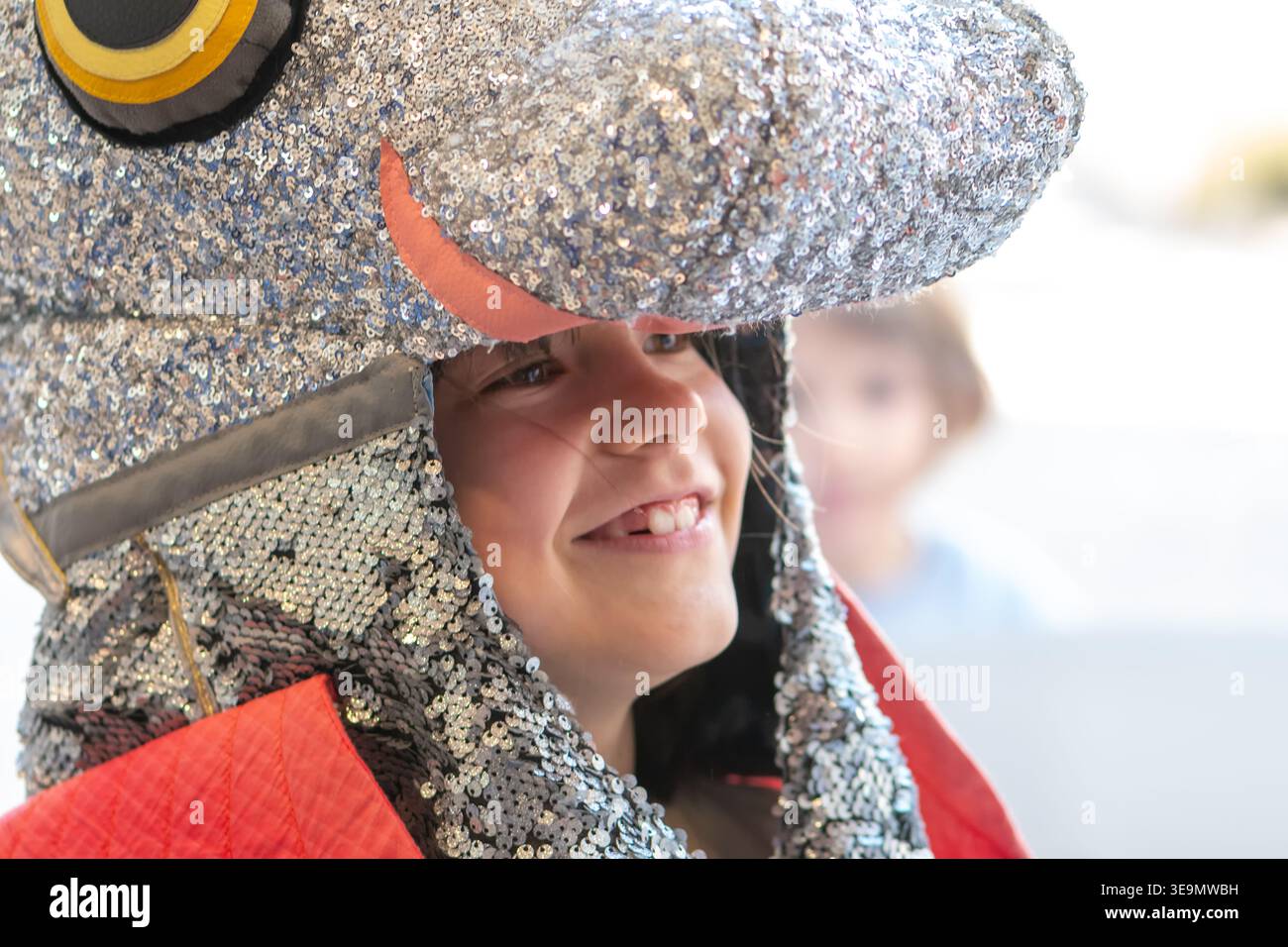 Ragazza di 7 anni in costume con casco lucido sorridente e giocante. Foto Stock