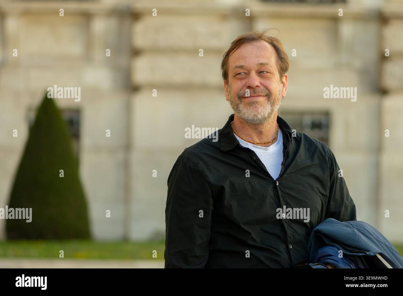 Uomo di 50-55 anni che guarda da parte mostrando fiducia calma controllo e umore positivo all'aperto. Foto Stock
