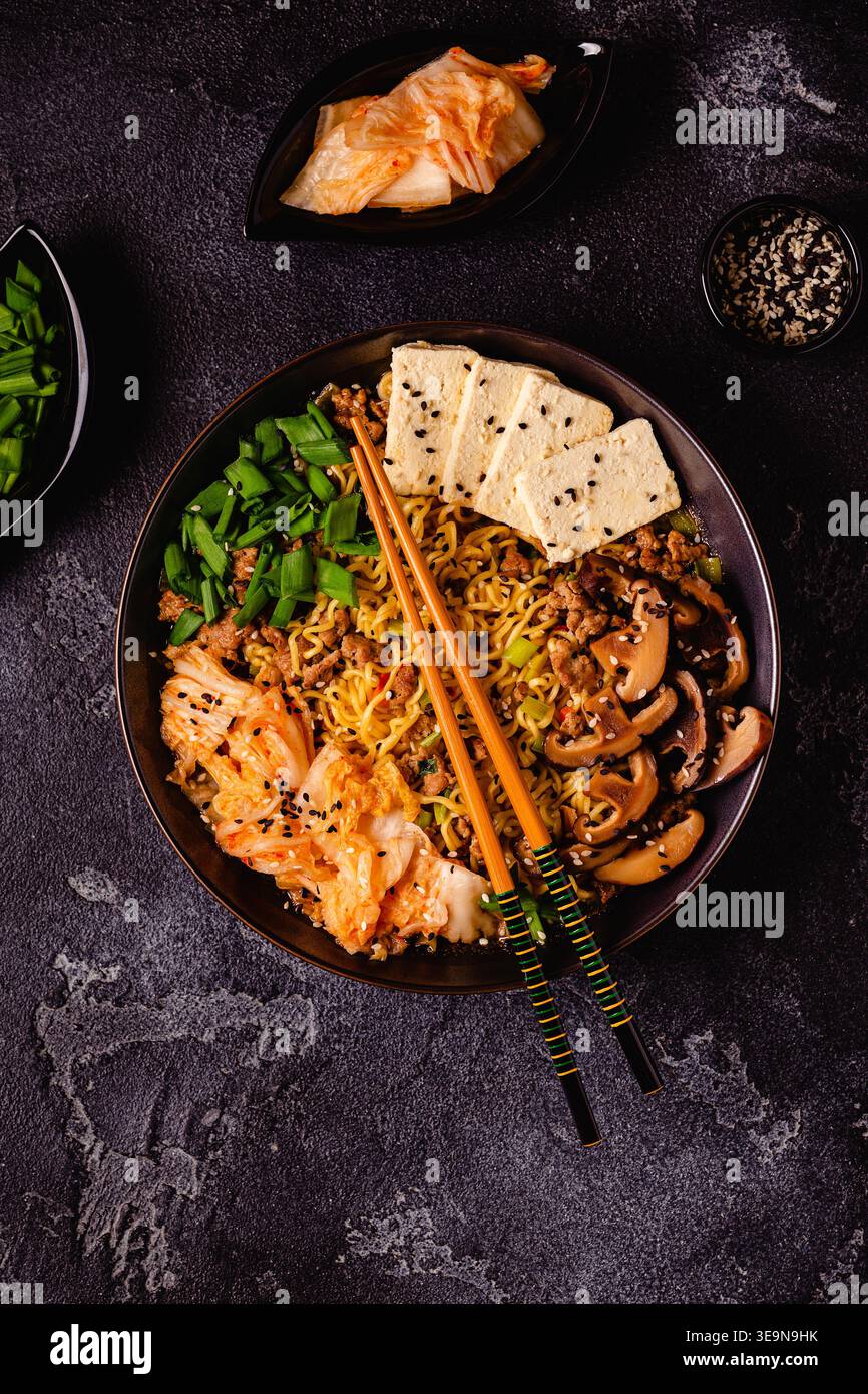 Spaghetti istantanei in stile coreano, Shin Ramyeon con carne macinata, kimchi, formaggio tofu, funghi shiitake. Foto Stock