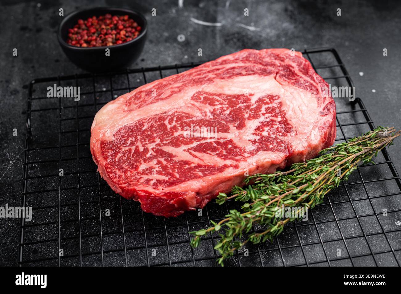 Bistecca cruda di riso nota anche come entrecote scotch o delmonico. Filetto di costolette di manzo marmorizzate tagliate su sfondo nero Foto Stock