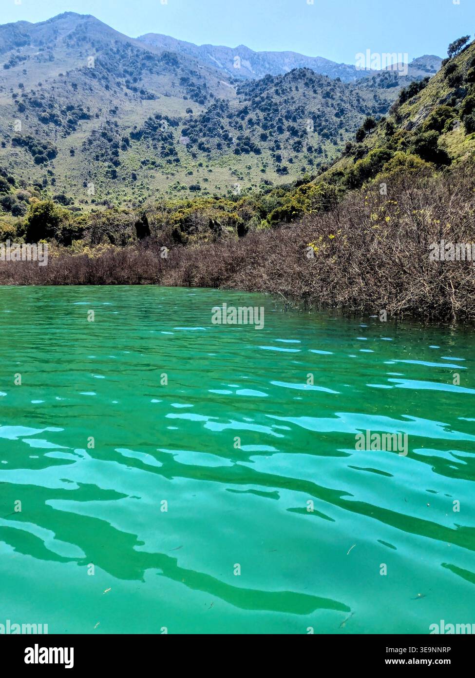 Lago calmo e blu circondato da verdi colline sul Lago Kournas Creta - Immagine stock catturata con smartphone