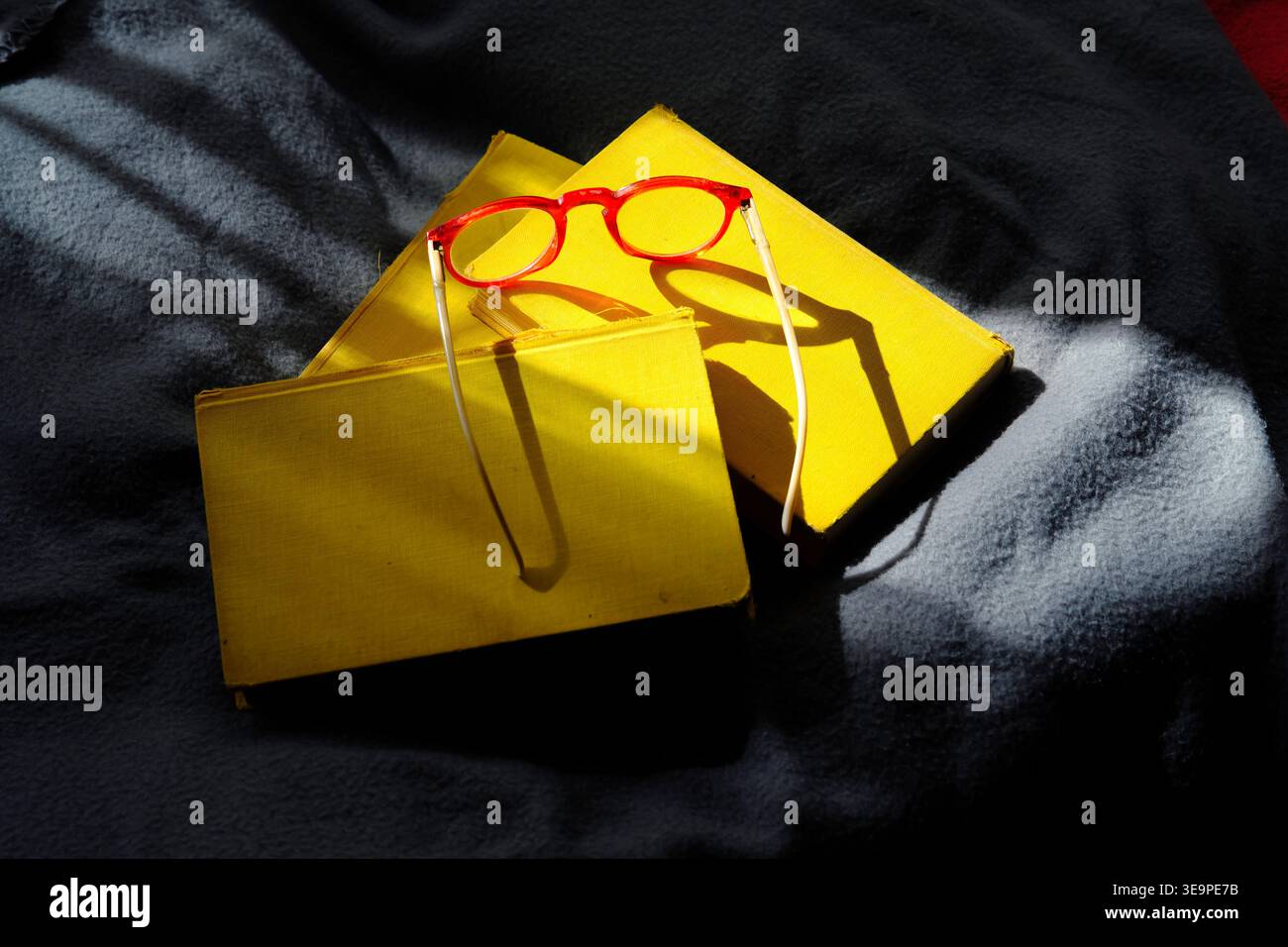 pila di libri gialli e occhiali alla luce del sole del mattino, educazione, lettura, letteratura, romanzo, ispirazione, concetto rilassante Foto Stock