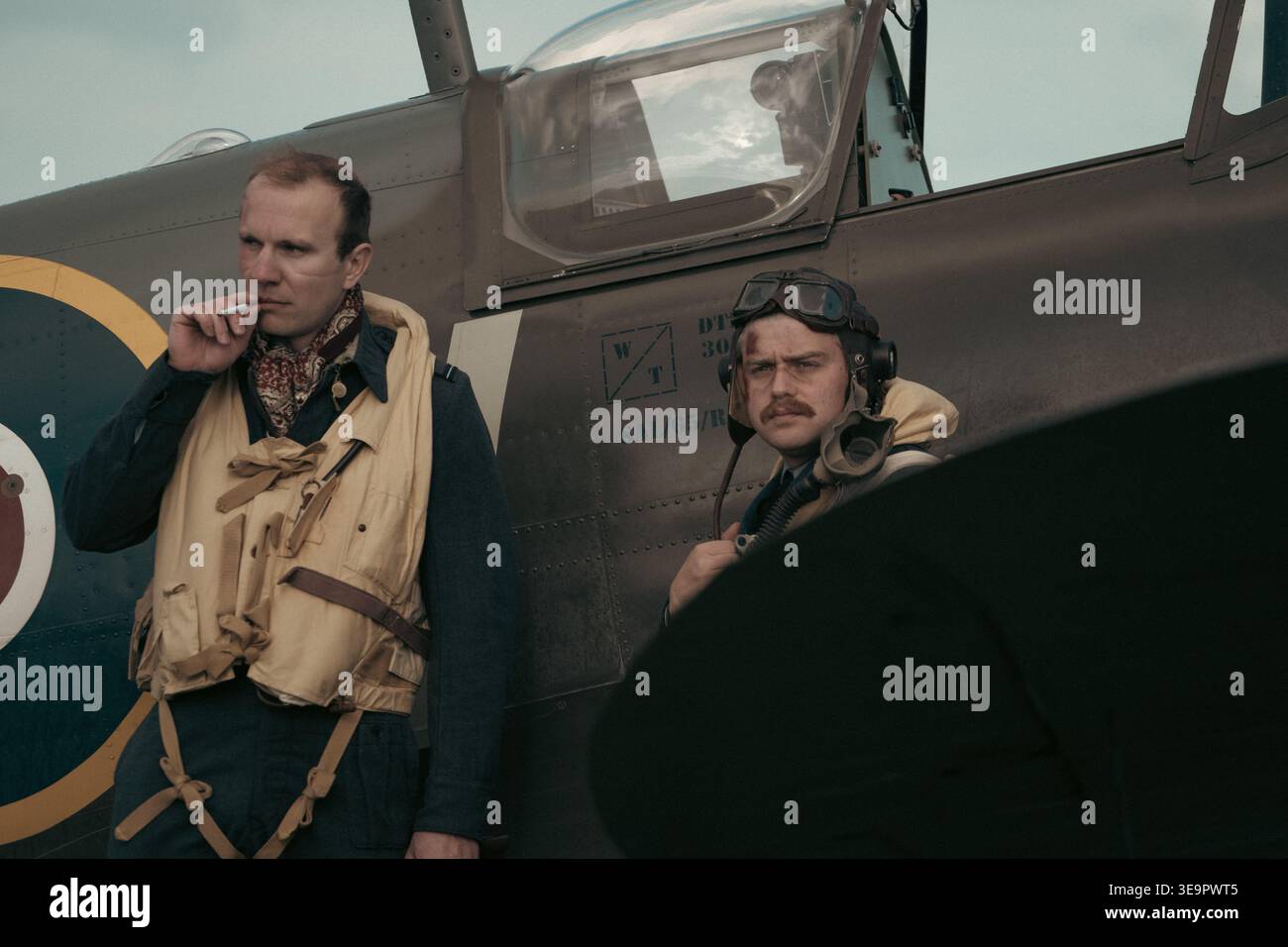 Due piloti della RAF feriti accanto allo Spitfire MkVc EE602 dopo essere tornati dalla battaglia, indossando giubbotti di salvataggio e equipaggiamento volante, rievocazione Sywell 1940s Foto Stock