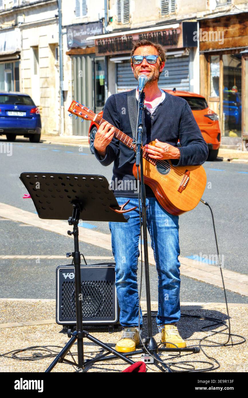 Cantante maschile con chitarra elettrica e altoparlante Vox che si esibisce in strada - le Blanc, Indre (36), Francia. Foto Stock