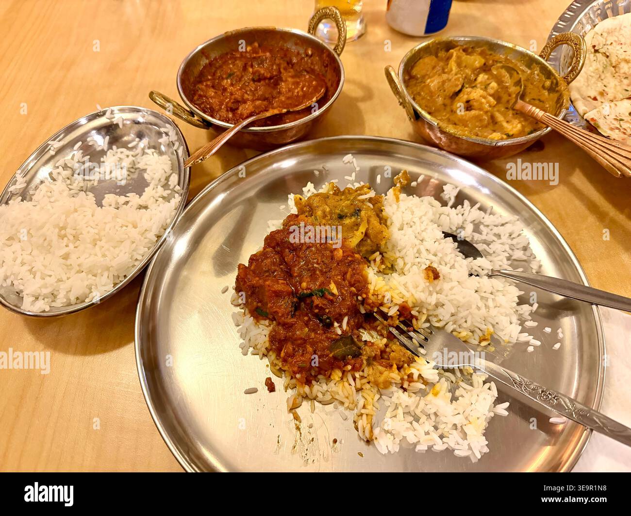 Delizioso pasto a base di curry indiano rogan josh di montone Kashmiri e riso basmati con le dita delle signore Foto Stock