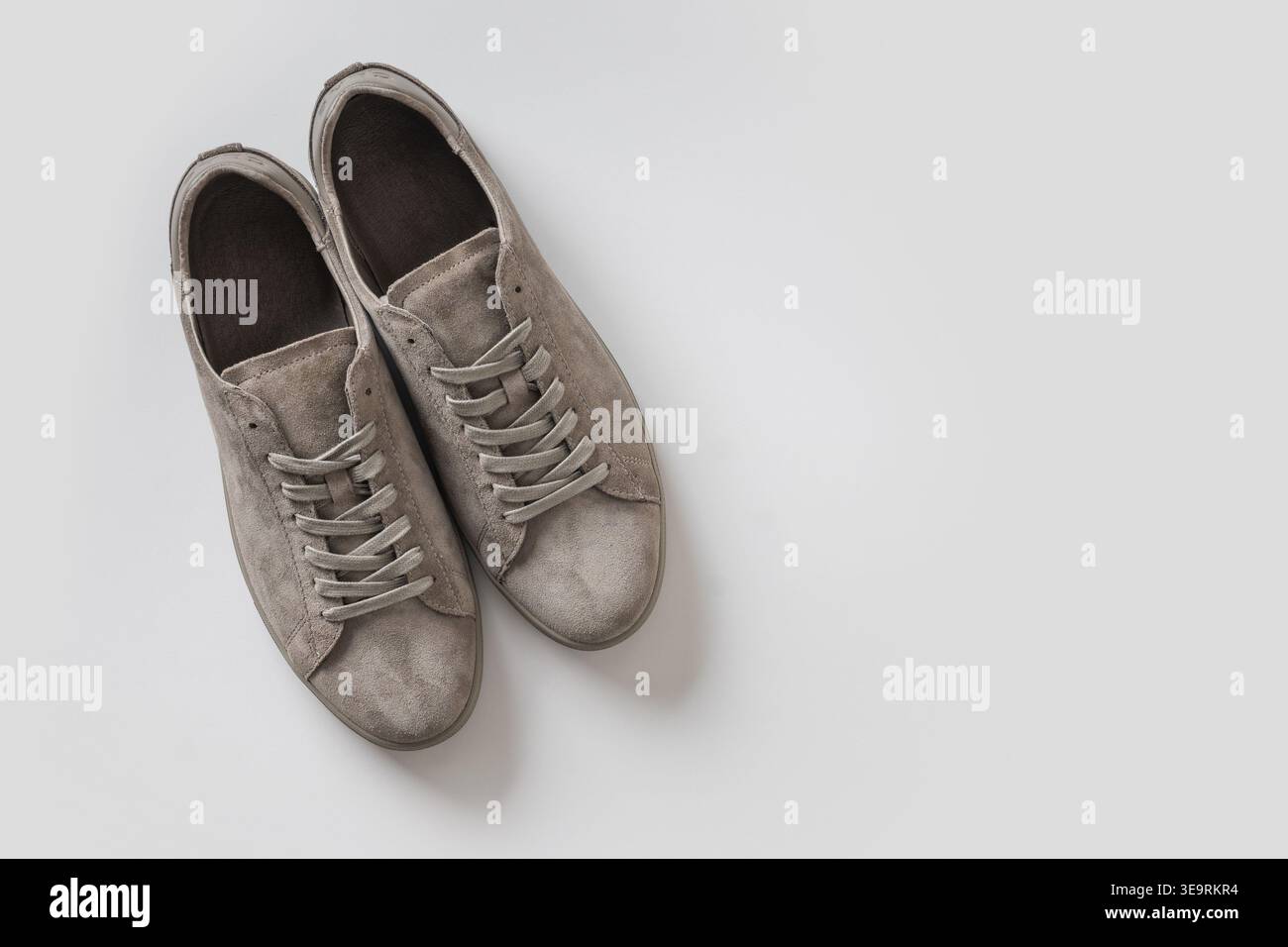 Un paio di sneaker in pelle scamosciata beige isolate su sfondo bianco, stile minimalista, layout pulito con spazio per le copie Foto Stock