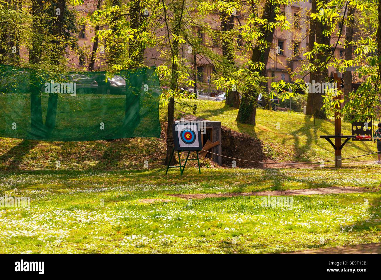Tiro con l'arco all'aperto tra gli alberi verdi primaverili Foto Stock
