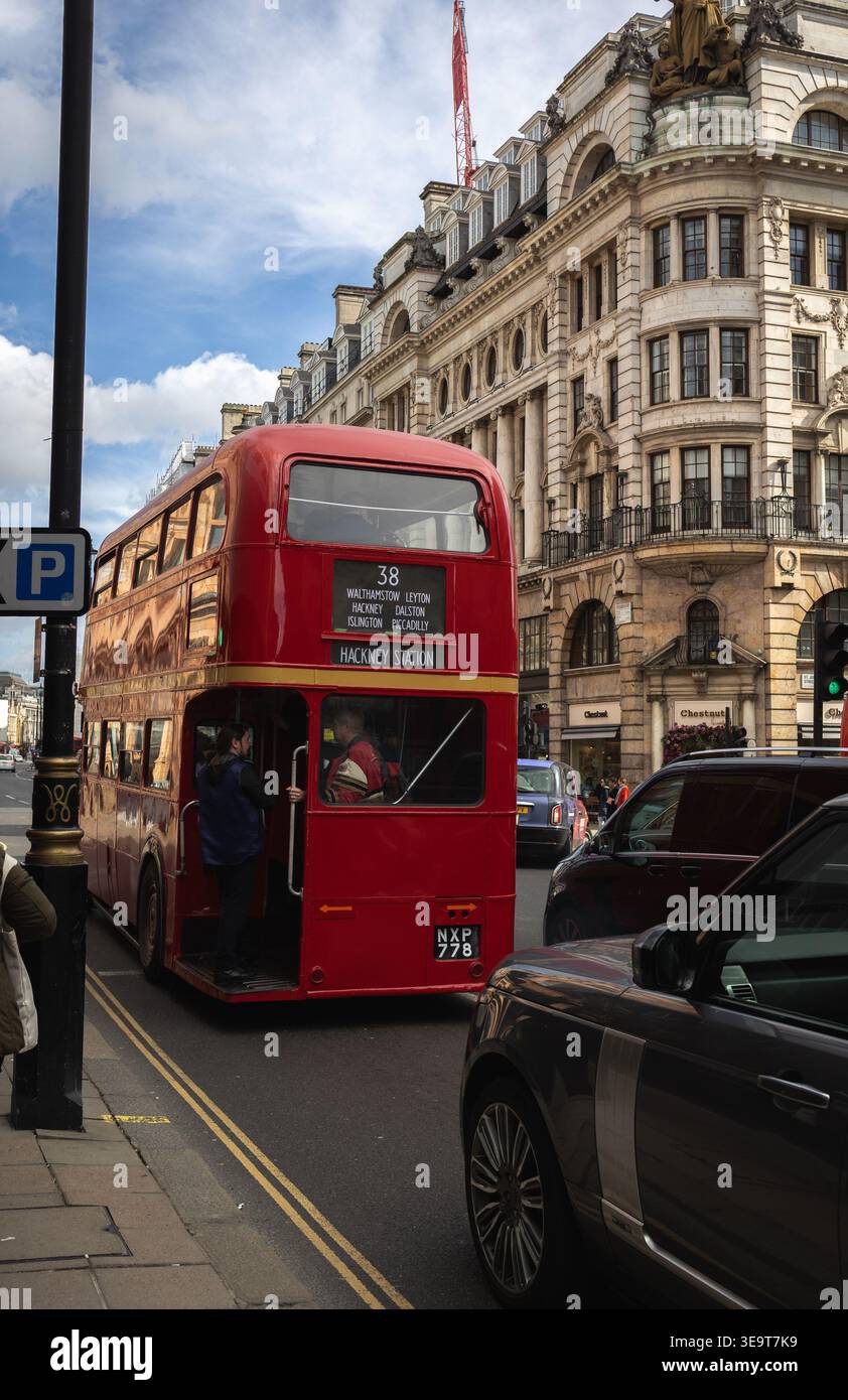 Autobus rosso d'epoca a due piani su London Street, con edifici storici e traffico, Regno Unito Foto Stock