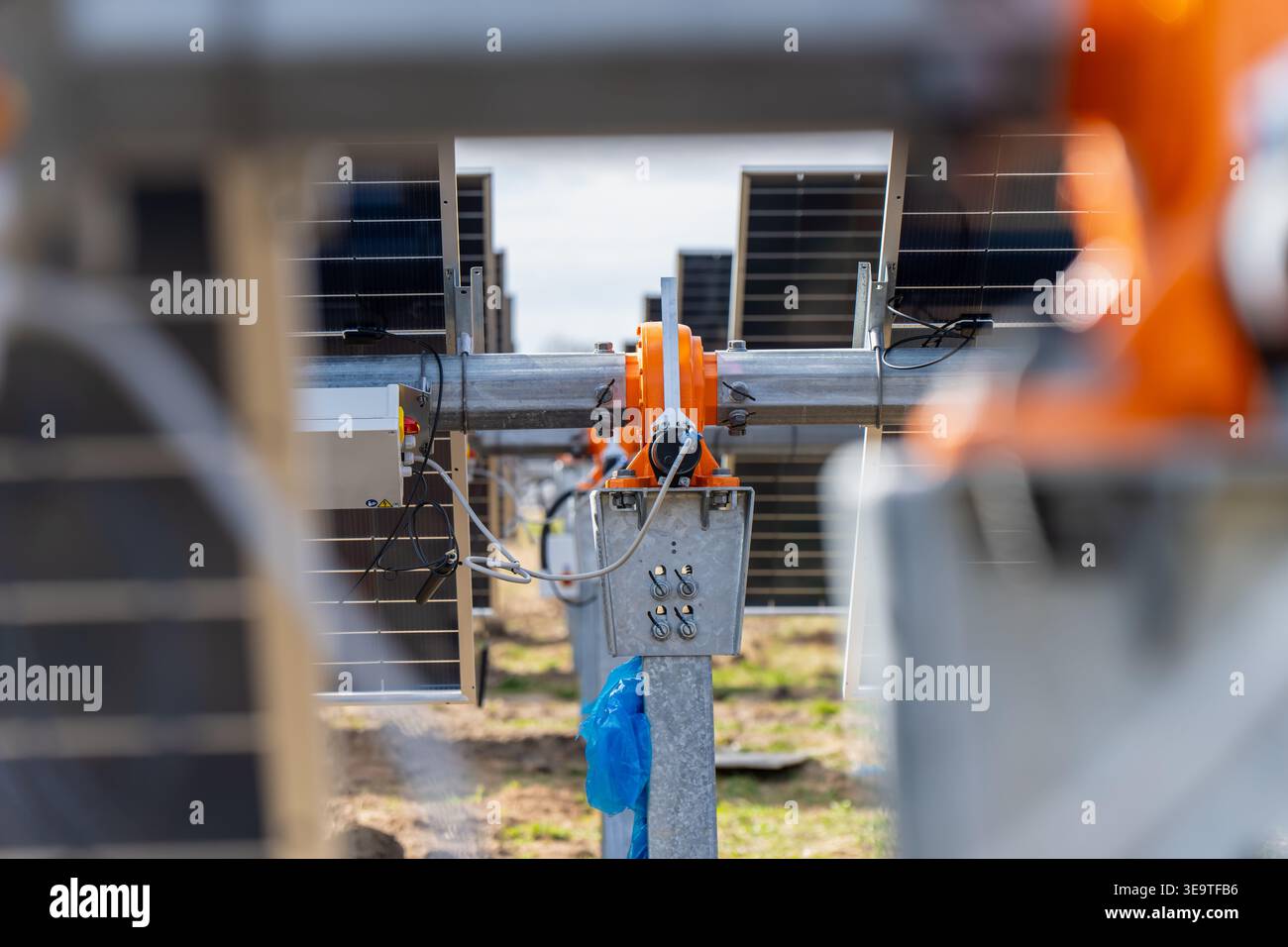 Fila di moduli fotovoltaici su un sistema di tracciamento dei metalli per la produzione di energia elettrica pulita in un progetto industriale di impianti solari durante la fase di costruzione in COU Foto Stock