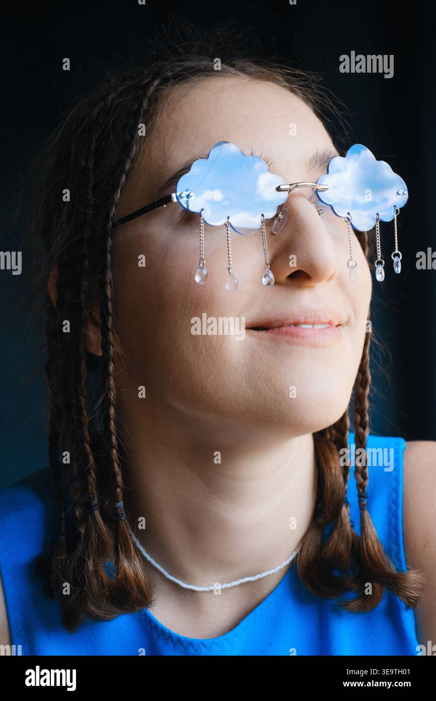 Ritratto ravvicinato di donna in esclusivi occhiali da sole a forma di nuvola con cristalli simili alla pioggia. Concetto creativo e surreale per moda, bellezza, arte o meteo Foto Stock