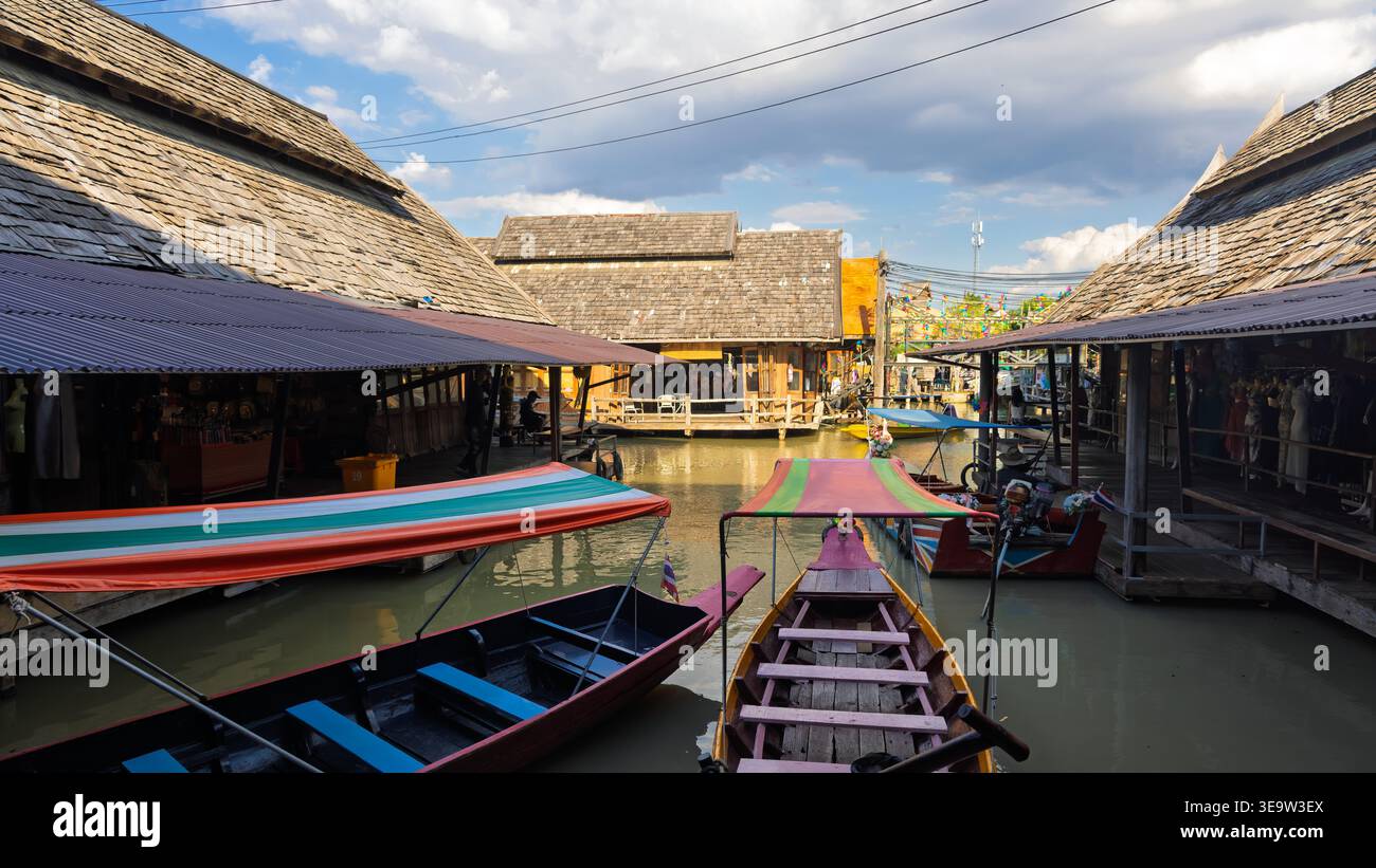 PATTAYA, THAILANDIA - 19 DICEMBRE 2023: Mercato galleggiante tradizionale con edifici in legno e barche a coda lunga su un canale Foto Stock
