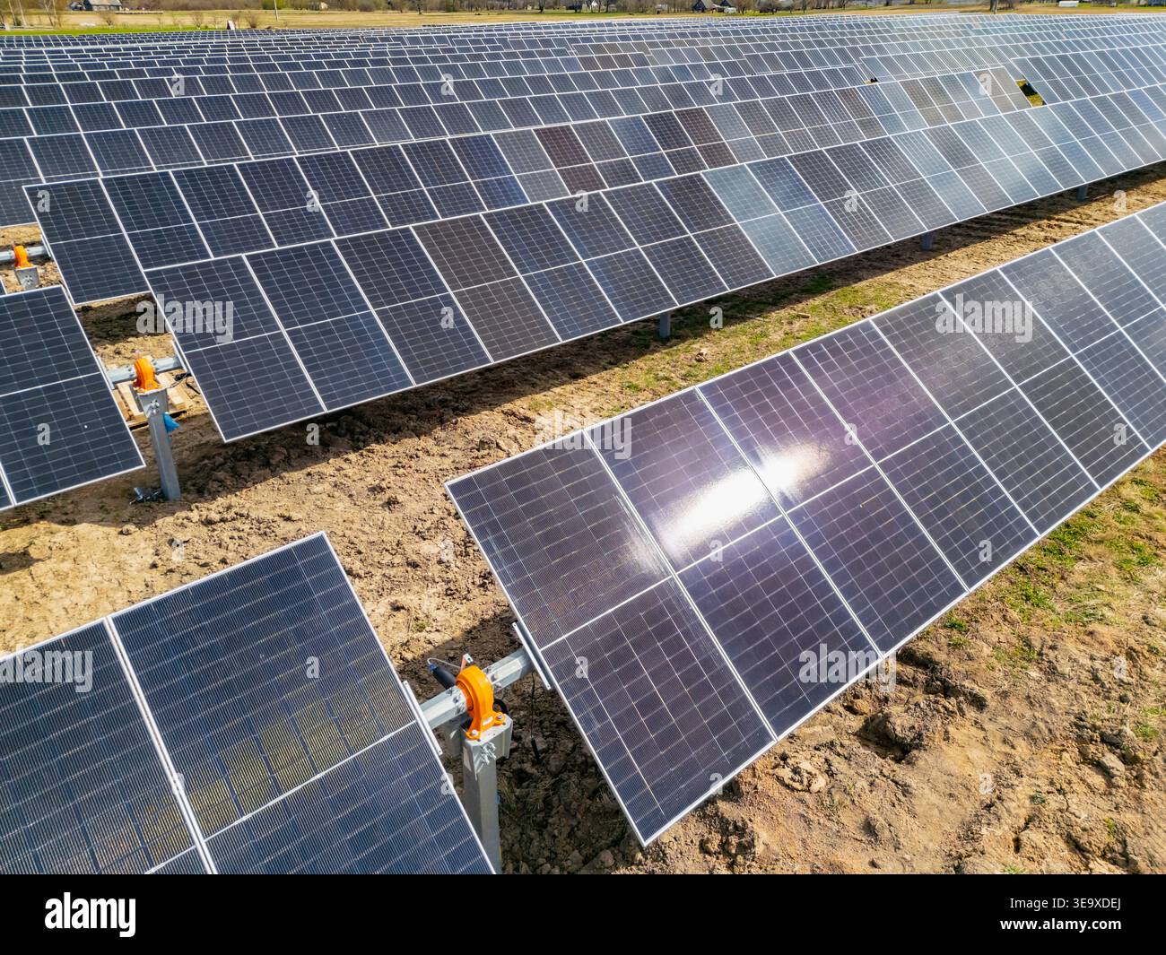 Moduli fotovoltaici moderni installati su sistemi di scaffalatura montati a terra in un cantiere di impianti a energia solare progettati per un impianto elettrico pulito e sostenibile Foto Stock