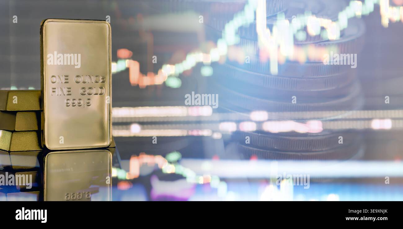 un'oncia di lingotti d'oro su una superficie riflettente con pile di monete sfocate e un grafico luminoso del mercato delle candele sullo sfondo, che rappresenta il gol Foto Stock