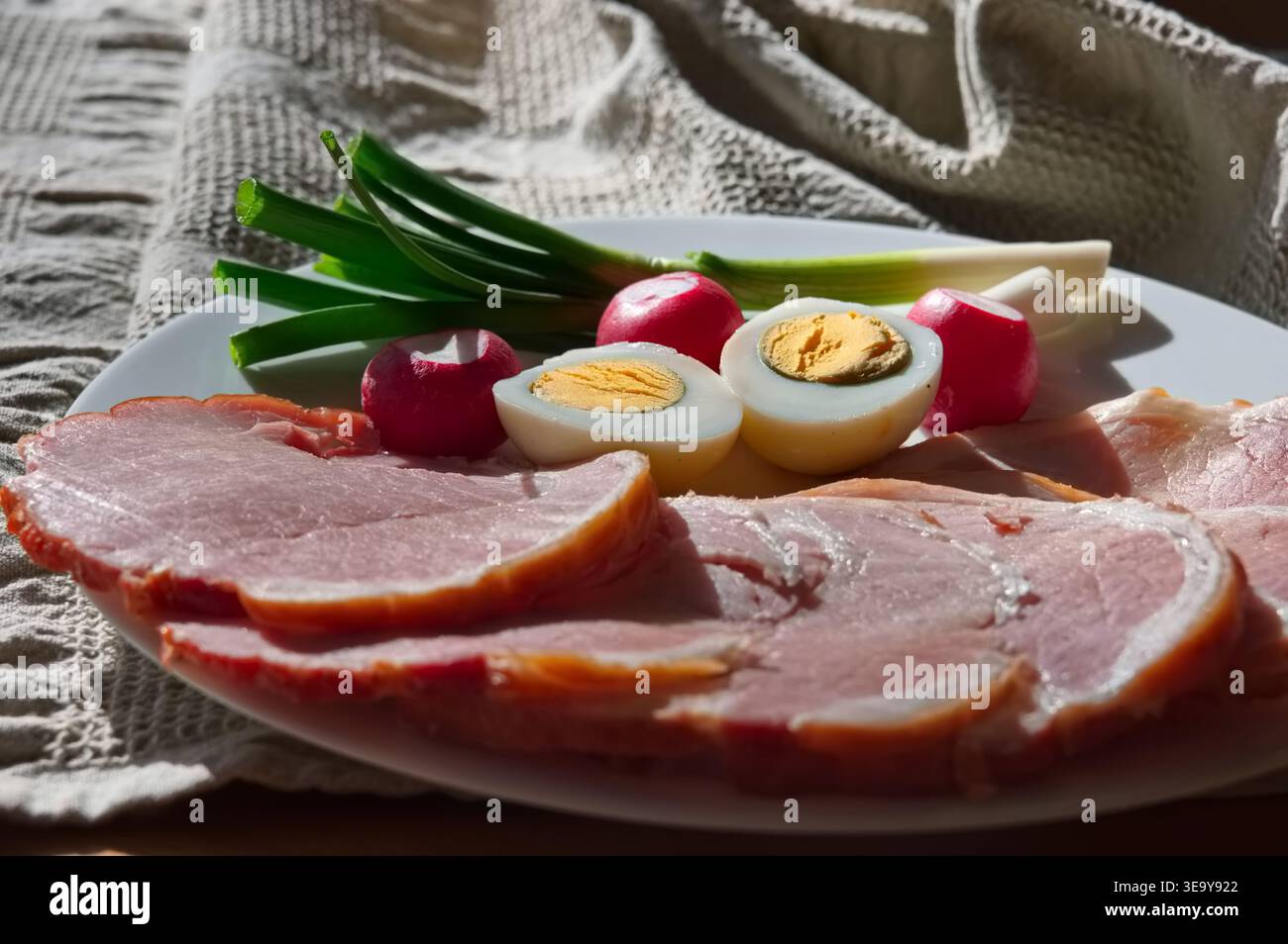 Primo piano di carne trasformata, uova, ravanello e cipolla di primavera sul tavolo Foto Stock