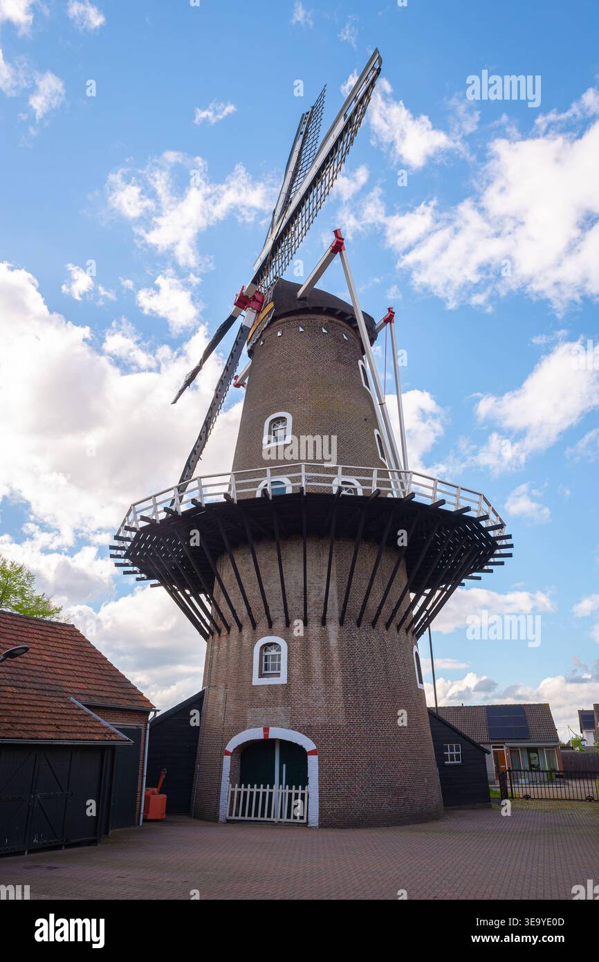 Tradizionale torre del mulino del grano contro un cielo blu con nuvole e dettagli architettonici storici. Foto Stock