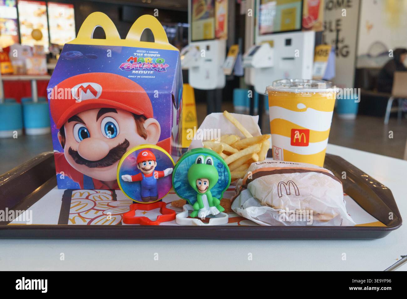 McDonald's Happy Meal con giocattoli promozionali Super Mario, confezioni a tema, patatine fritte e bevande esposte su un vassoio all'interno di un ristorante a Cebu City, Phili Foto Stock