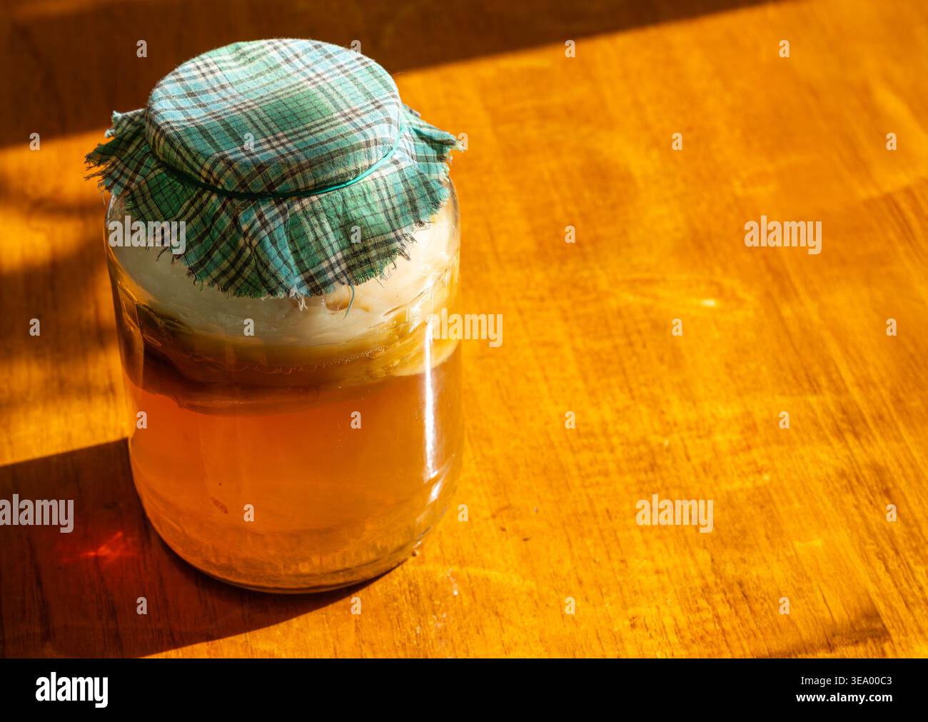 Tè kombucha fermentato in vaso di vetro con scoby su fondo rustico in legno Foto Stock