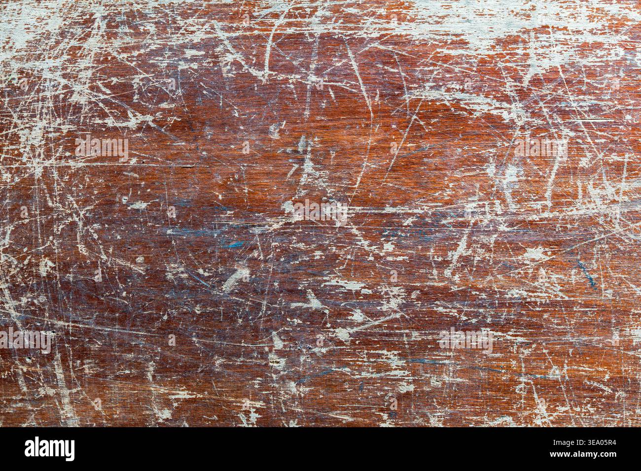 Superficie rustica in legno marrone con pesanti graffi e residui di vernice bianca intemprata. Ideale per sfondi grunge, design industriale e vintage Foto Stock