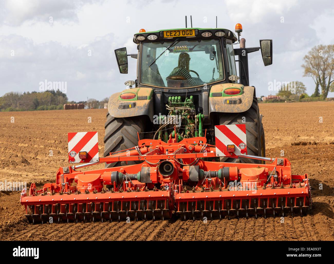 Trattore di medie dimensioni John Deere 6R 185 con erpice Kuhn HR per la preparazione intensiva del letto di semina. Shottisham, Suffolk, Inghilterra, Regno Unito Foto Stock
