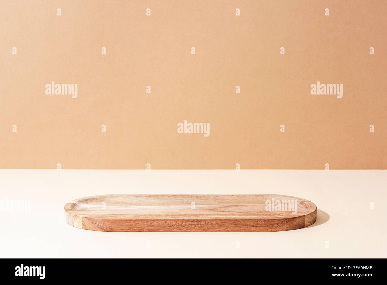 Vassoio in legno su sfondo beige. Composizione naturale minima, mockup. Vista frontale Foto Stock