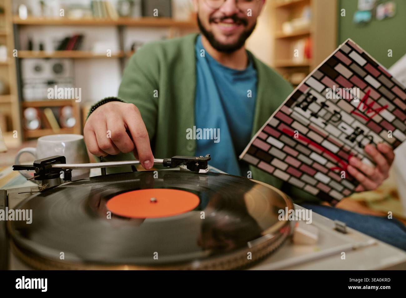 Uomo adulto che suona il disco in vinile a casa per il concetto di stile di vita musicale Foto Stock