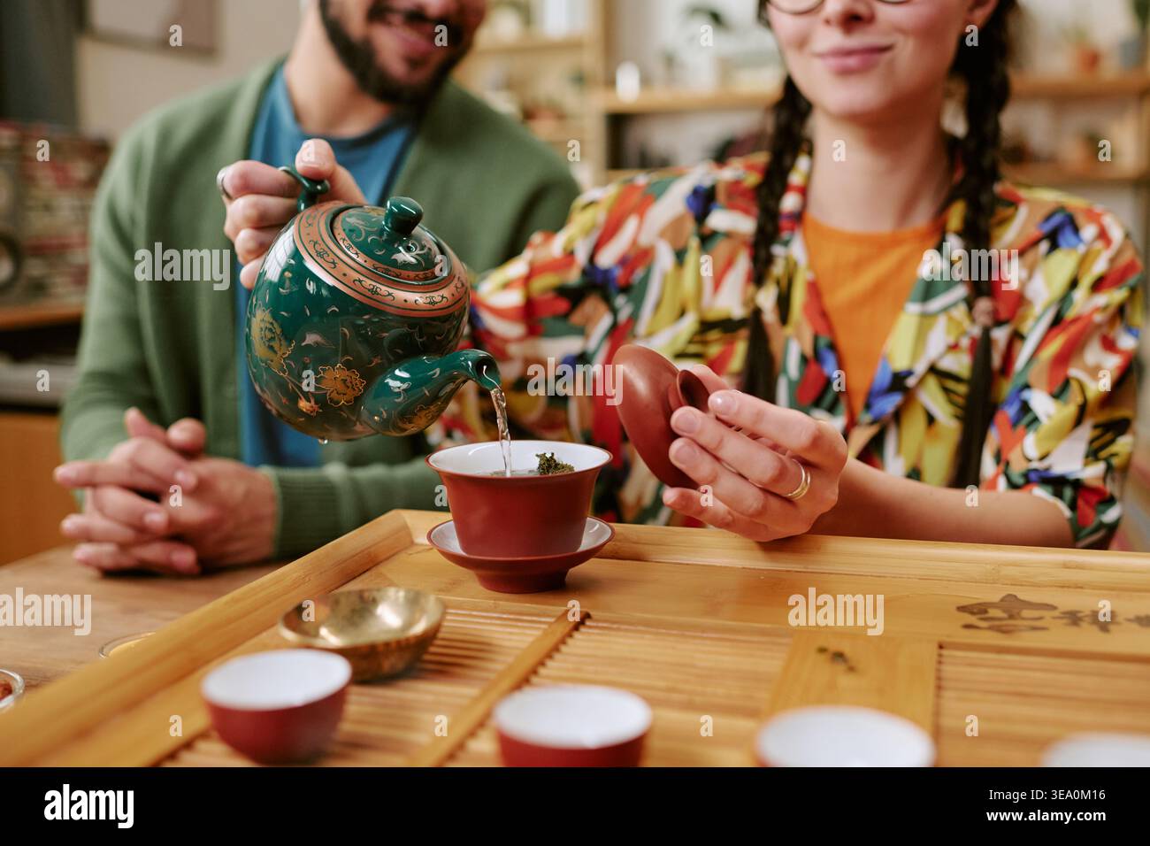 Donna adulta che versa il tè durante il rituale Mindful Wellness a casa Foto Stock