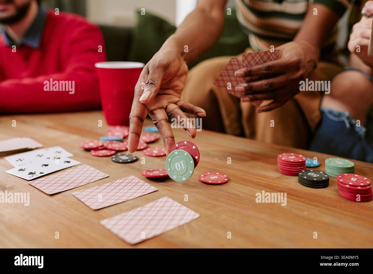 Black Woman Dealing Cards e Poker Chips durante la serata della partita in casa Foto Stock